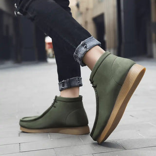 Olive green ankle boots with tan soles.