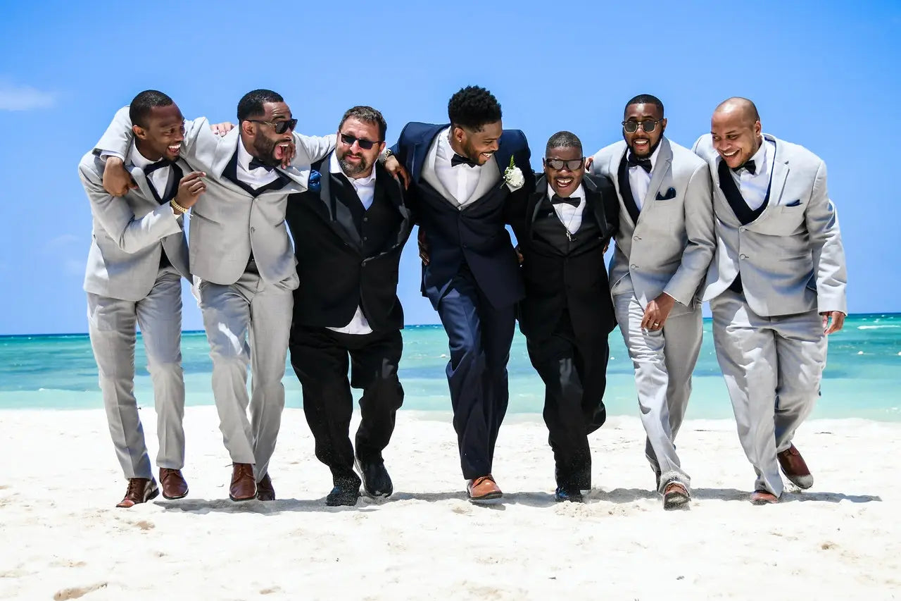 A group of wedding guests smiling on the beach