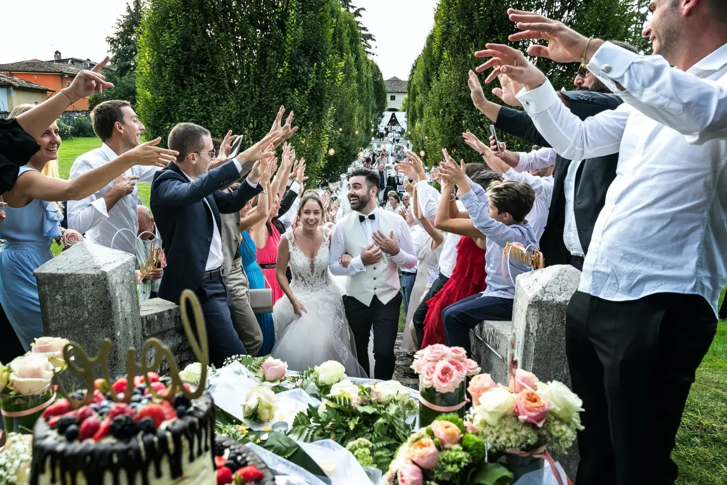 A bride and groom walking through a crowd of happy people celebrating